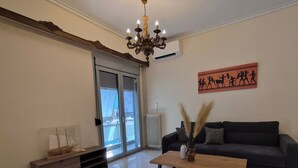 Ein Wohnzimmer mit einer Chandelieber, einem Sofa, einem Couchtisch und einem dekorativen Teppich.