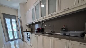 Eine moderne Küche mit weißen Schränken, einer Edelstahl-Arbeitsplatte und einem Deckenventilator.