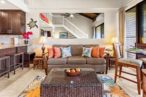 A spacious living area with a sofa, coffee table, and a view of a staircase leading to an upper level. - Stunning West Maui Oceanview Retreat (Honokowai)