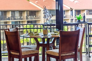 A balcony with a table set for two, chairs, a decorative orchid, and a bottle of wine. - Stunning West Maui Oceanview Retreat (Honokowai)