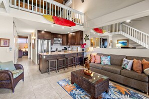 A spacious living area with a kitchen, a dining area, and a staircase. - Stunning West Maui Oceanview Retreat (Honokowai)