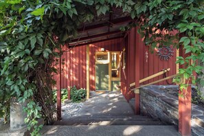 A red wooden building with a stone staircase leading to a door. - The Gallery House | Architectural Digest–Featured Ketchum Home (Ketchum)