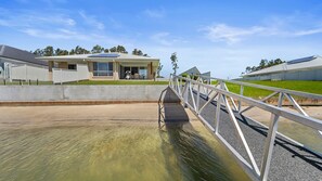 A residential area with a house, a solar panel, a swimming pool, and a bridge.