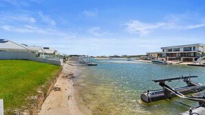 A waterfront property with a clear view of the water, boats, and modern buildings. - Yamba Waters - Pet Friendly Waterfront Escape with Private Jetty (Yamba)