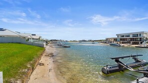 A waterfront property with a clear view of the water, boats, and modern buildings. - Yamba Waters - Pet Friendly Waterfront Escape with Private Jetty (Yamba)