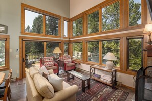 A spacious living room with large windows, a fireplace, and a cozy seating area.