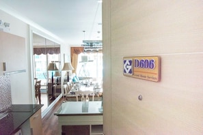 Ein Hotelzimmer mit Essbereich, einem großen Fenster und einem Schild mit der Aufschrift Grand Room Services.