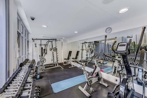 A gym with various exercise equipment, including treadmills, weight machines, and free weights. - Spacious 3BR | Pool, Gym, Tennis & Parking (Brisbane)
