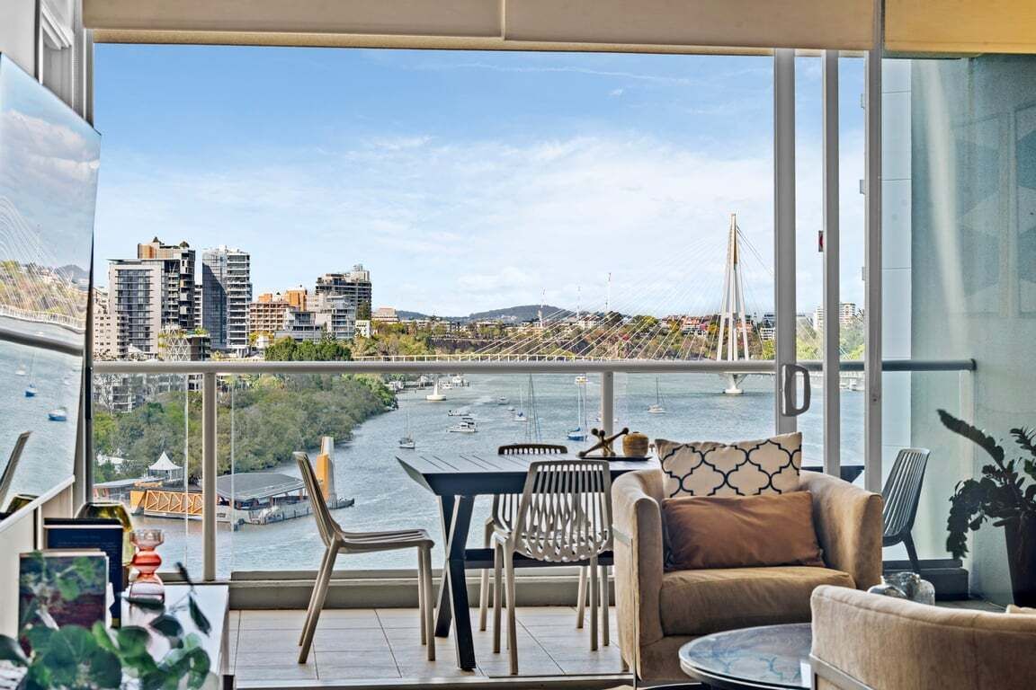 A balcony with a city view, a dining table, and seating.