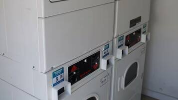 A row of stacked laundry machines in a room.