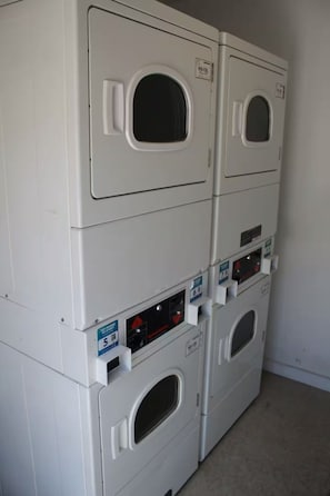 A row of stacked laundry machines in a room.