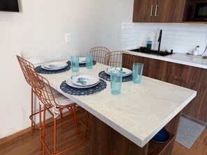 A dining table set with plates, glasses, and a knife rest. - Gabbiani by GPS, Elegancia en Zona Dorada (Mazatlán)