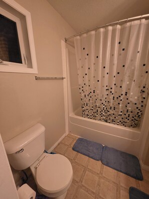 Ein Badezimmer mit Toilette, Badewanne und Duschvorhang.
