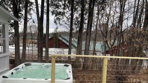 A hot tub on a wooden deck with a wooden fence in the background.