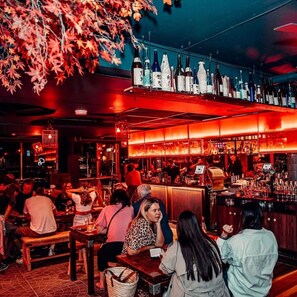 A bar with wooden furniture and a variety of bottles on shelves. - Sunny Balcony, Luxury in the Heart Of Bondi Beach (Bondi Beach)
