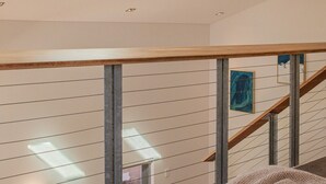 A modern bedroom with skylights, a wooden staircase, and a bed with a knitted blanket. - Sunny Balcony, Luxury in the Heart Of Bondi Beach (Bondi Beach)