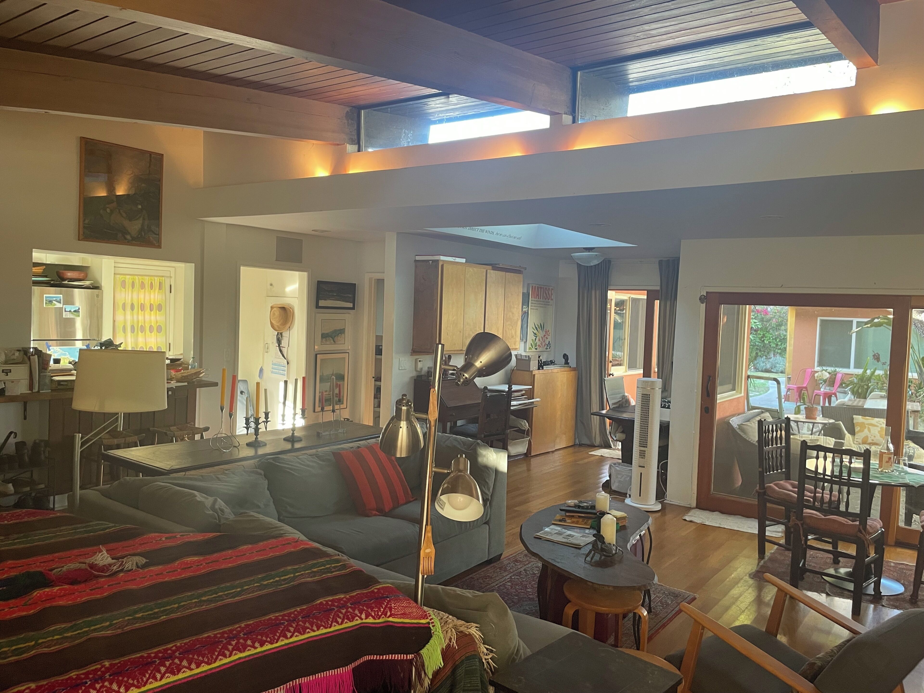 A spacious living area with a sofa, a dining table, and a kitchen in the background.