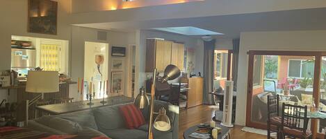 A spacious living area with a sofa, a dining table, and a kitchen in the background.