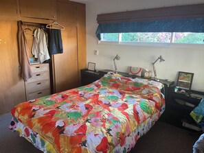 Una camera da letto con un letto, un armadio, una scrivania, una finestra e un comodino.