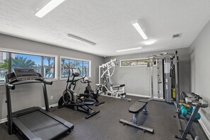 Ett gym med konditionsmaskiner, styrketräningsmaskiner och hantlar.