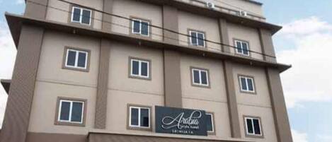 A multi-story hotel with a sign reading 'Aralia Hotel'.