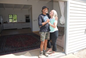 A couple standing in a doorway with a kitchen in the background.