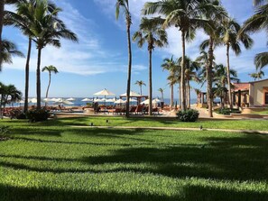 A resort with a pool area, palm trees, and a view of the ocean. -  Playa Grande Penthouse 2-Bedroom Suite on the Ridge Christmas & New Years weeks (Cabo San Lucas)