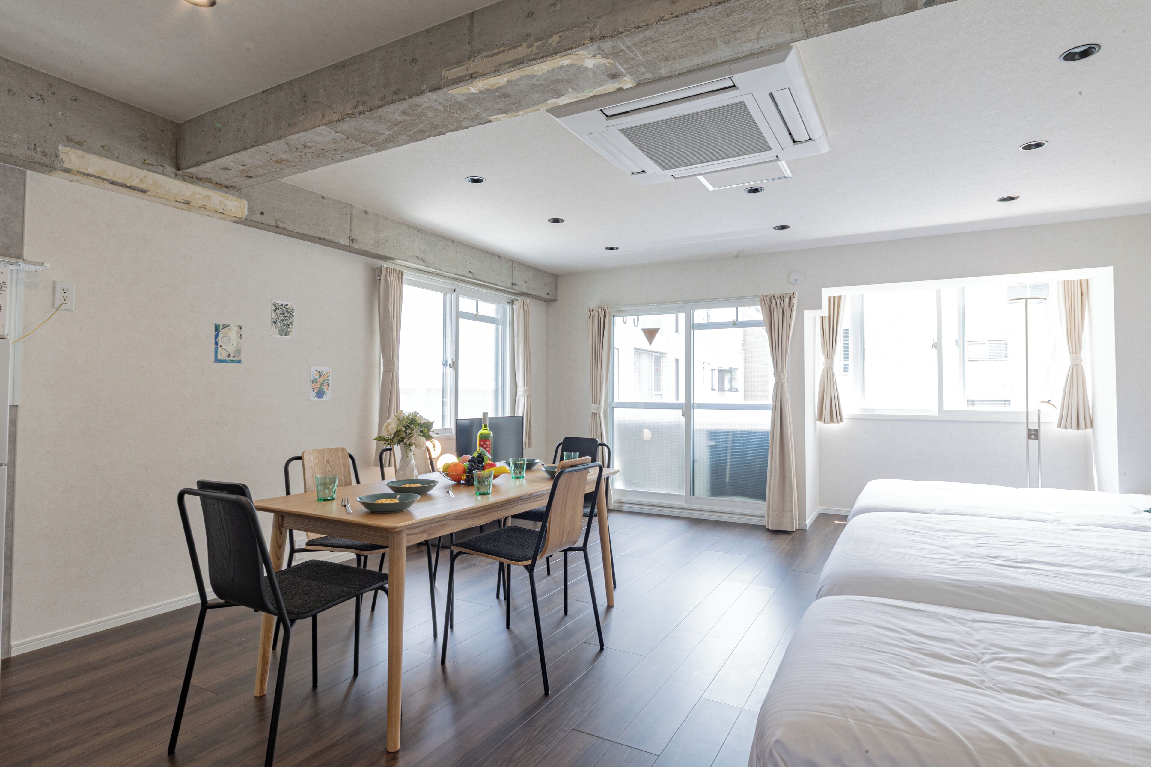 Habitación de hotel con zona de comedor, cama y balcón.