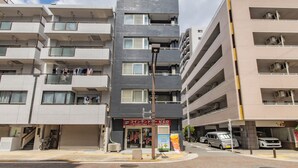 A multi-story residential building with balconies, a ground-level entrance, and a visible storefront with signage. - AS7 Building (Sumida-ku)