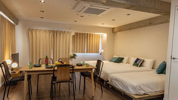 A hotel room with a dining area, two beds, and a window with curtains. - AS7 Building (Sumida-ku)