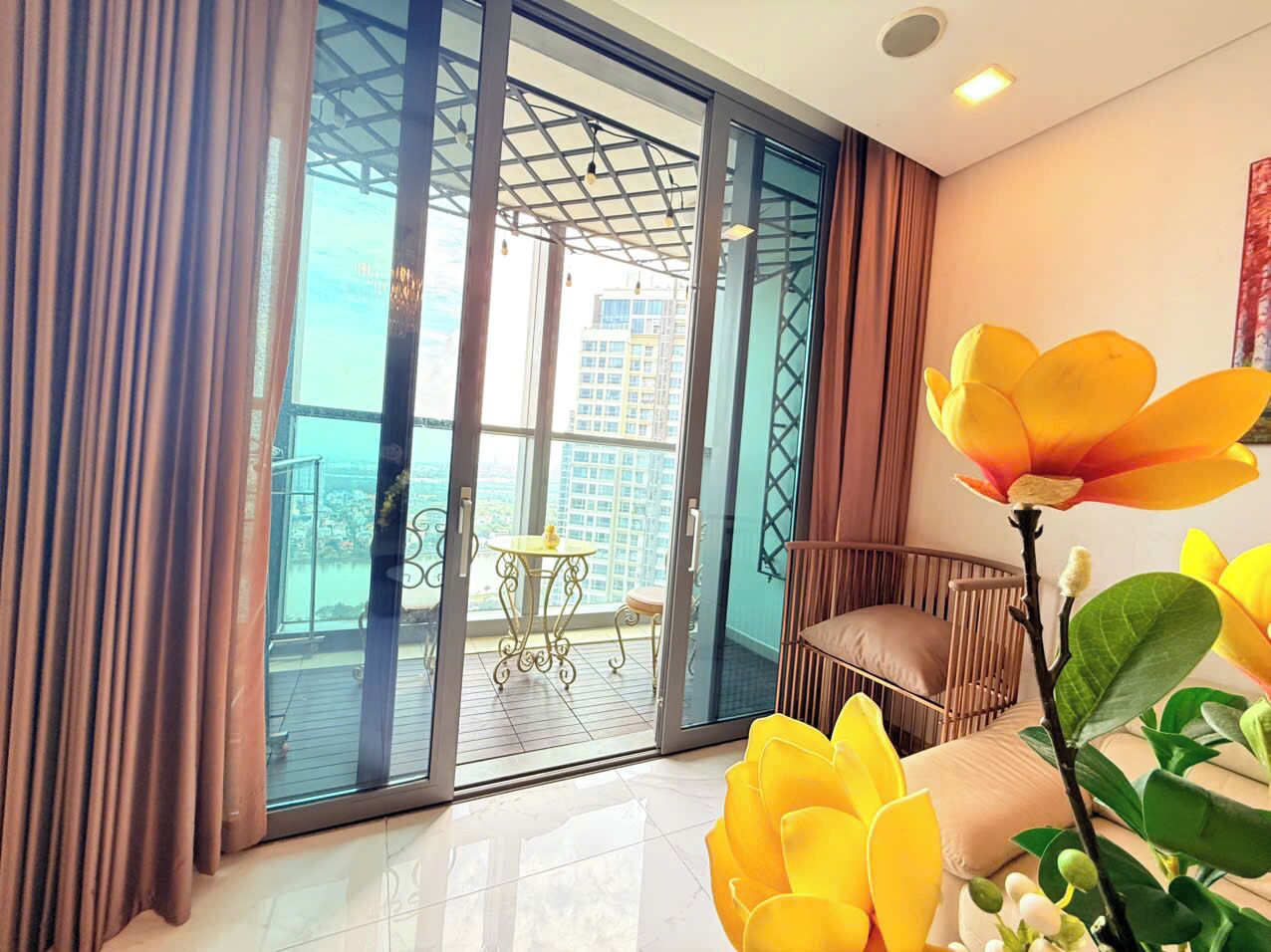 A modern interior with a sliding glass door leading to a balcony, a small table, and a cushioned seating area.