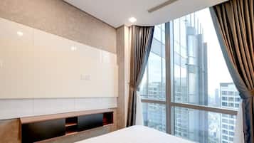 A hotel room with a large window, a bed, a built-in TV, and a wall-mounted shelf.