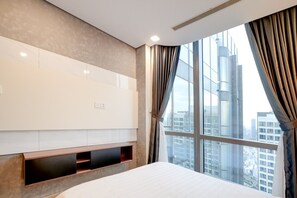 A hotel room with a large window, a bed, a built-in TV, and a wall-mounted shelf. - Landmark 81 Serviced Apartment - Mariana (Ho Chi Minh City)