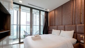A modern hotel room with a large bed, a TV, and a view of the city through floor-to-ceiling windows. - Landmark 81 Serviced Apartment - Mariana (Ho Chi Minh City)