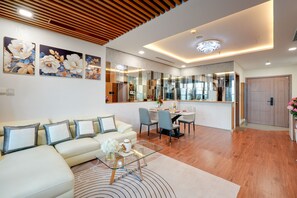 A modern living room with a sofa, coffee table, and dining area. - Landmark 81 Serviced Apartment - Mariana (Ho Chi Minh City)