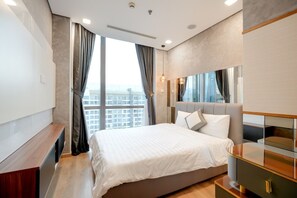 Ein modernes Schlafzimmer mit einem großen Bett, einem Fernseher und Blick auf die Stadt.