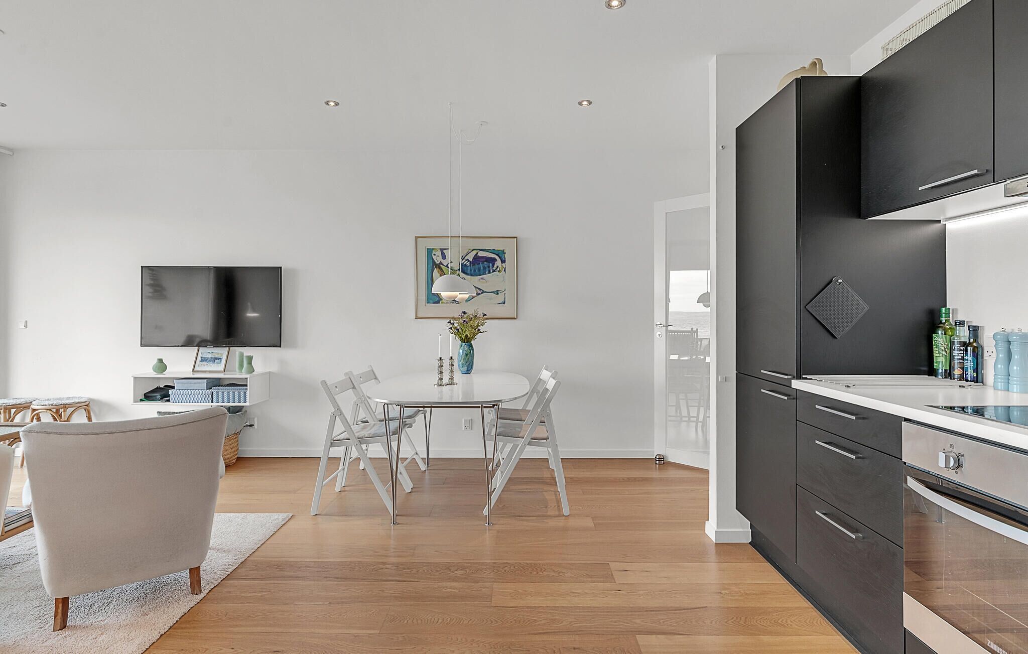 A modern kitchen with dark cabinets, a white countertop, and a built-in oven.