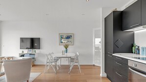 Una cocina moderna con armarios oscuros, una encimera blanca y un horno empotrado.