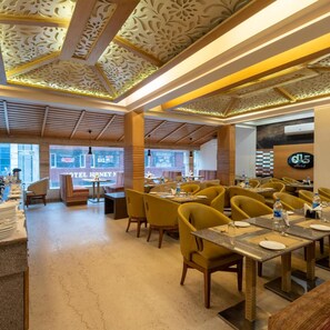 A restaurant interior with wooden beams, yellow chairs, and a patterned ceiling. - DLS Spring Valley Resort, Dharamshala (Dharamshala)