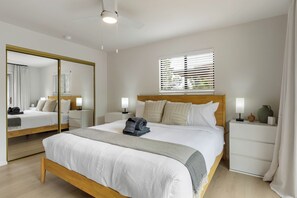 A modern bedroom with a large bed, bedside tables, a mirror, and a ceiling fan. - West Sedona retreat with 4 bedrooms, hot tub, and Red Rock views. (Sedona)
