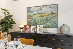 A dining area with a table set for two, a potted plant, a painting, and a couple of books on the table. - West Sedona retreat with 4 bedrooms, hot tub, and Red Rock views. (Sedona)
