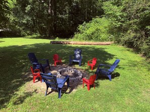 A circular seating arrangement around a fire pit with chairs in blue and red colors. - Spacious 4-bedroom house in charming Ringgold with big yard and pet friendly. (Ringgold)