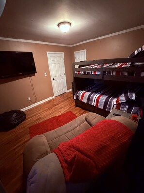 A room with a bunk bed, a television mounted on the wall, and a door. - Spacious 4-bedroom house in charming Ringgold with big yard and pet friendly. (Ringgold)