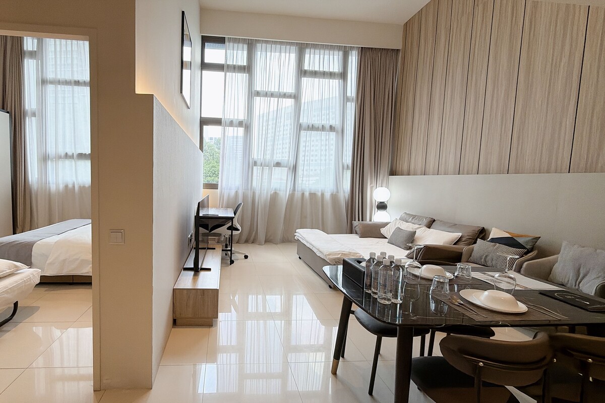 Habitación de hotel con cama, escritorio con silla, mesa de comedor con sillas y sofá.