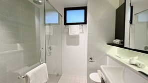 A modern bathroom with a glass-enclosed shower, a toilet, a sink with a mirror, and a towel rack. - Moulmein Studios by K&C Serviced Apartment (Singapore)