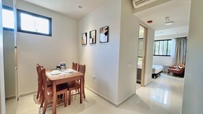 A modern hotel room with a dining area, a bed, and a view of the outdoors. - Moulmein Studios by K&C Serviced Apartment (Singapore)