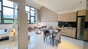 A modern kitchen with a dining area, large windows, and a view of the city.