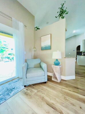 A living room with a sofa, a lamp, and a painting on the wall. - Coastal Paradise Near the Beach - Private Heated Pool - 4BR Marco Island Retreat (Marco Island)