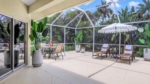 A covered outdoor area with seating and potted plants. - Coastal Paradise Near the Beach - Private Heated Pool - 4BR Marco Island Retreat (Marco Island)
