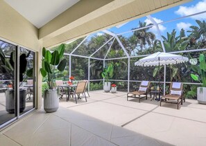A covered outdoor area with seating and potted plants. - Coastal Paradise Near the Beach - Private Heated Pool - 4BR Marco Island Retreat (Marco Island)